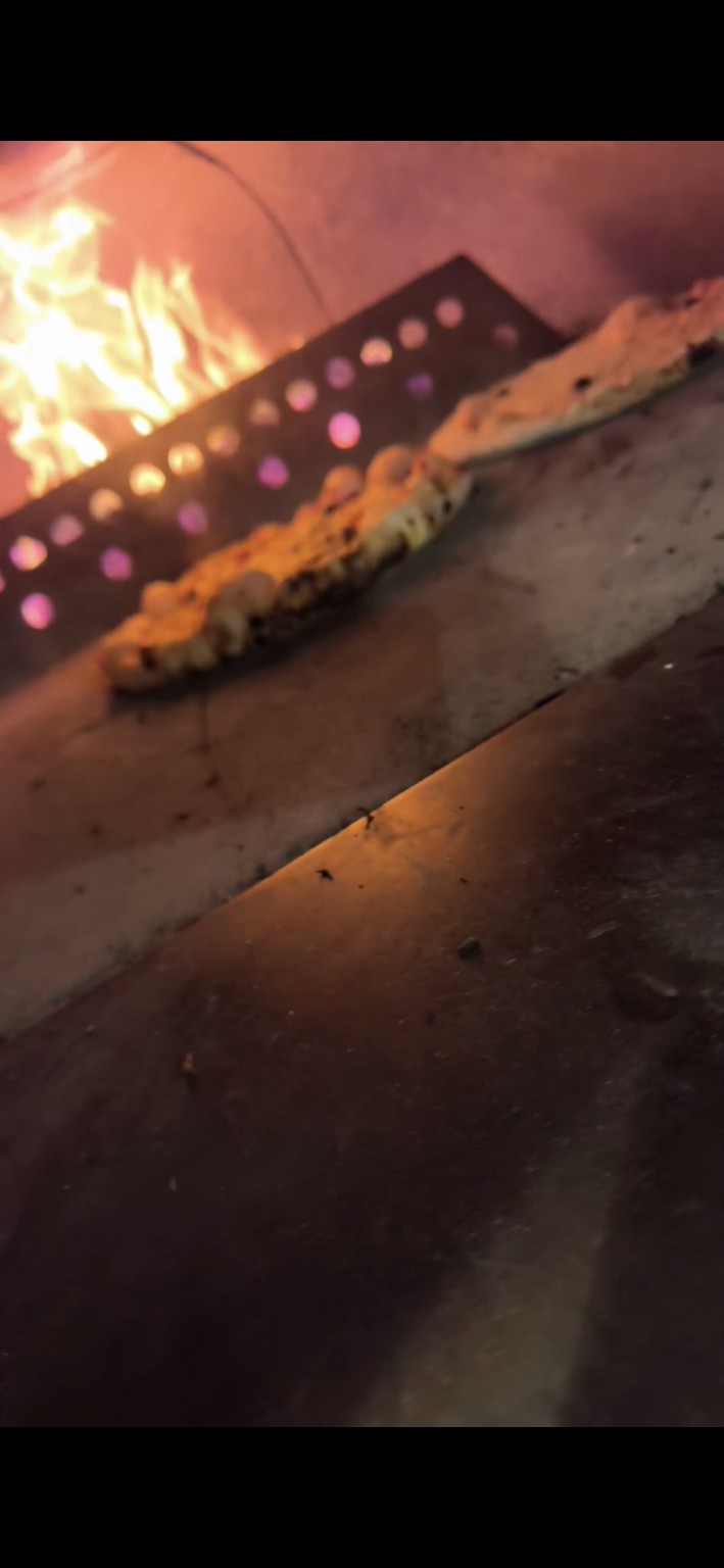 Pizza en cuisson dans le four à bois